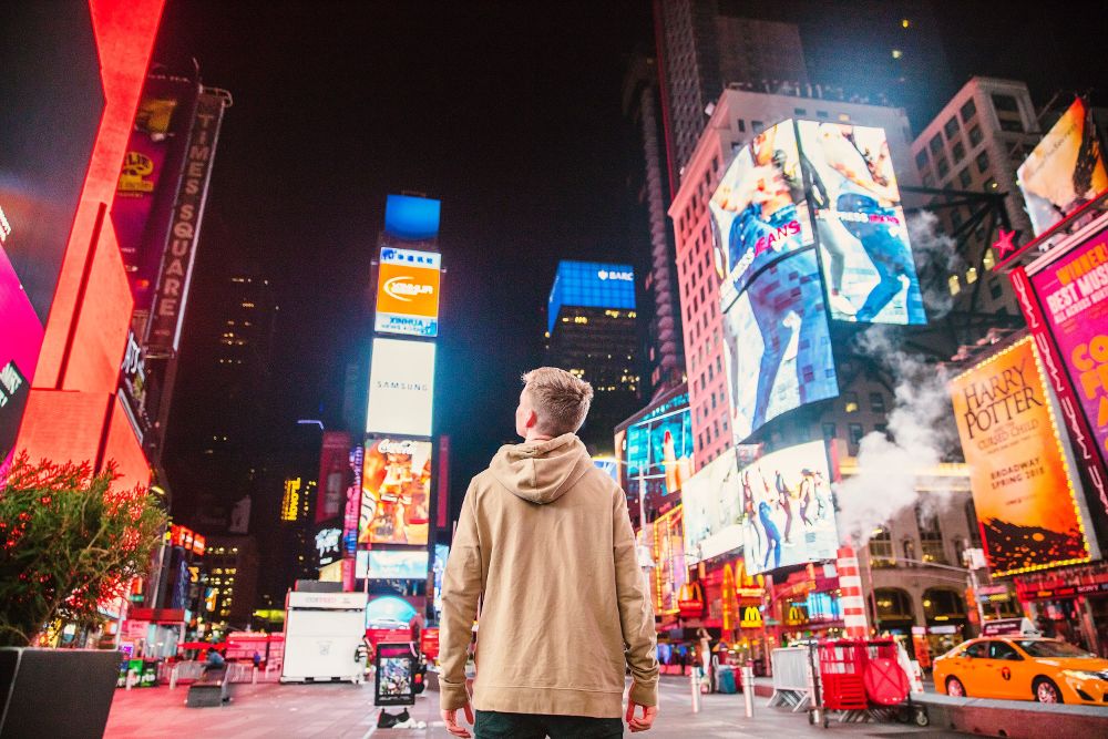 Man looking at street advertisements